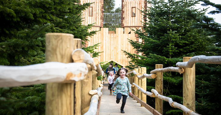 children running and playing in the Plotter's Forest playground at Raby Castle
